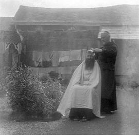 Capuchin Friar receiving a haircut